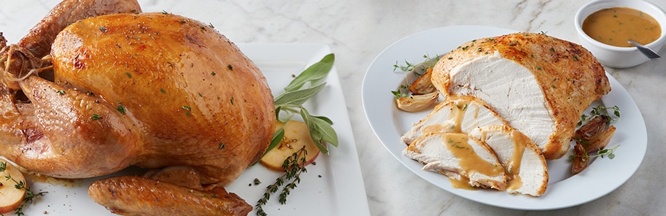 Two roasted turkeys displayed on marble background to show turkey brining done in multiple ways.