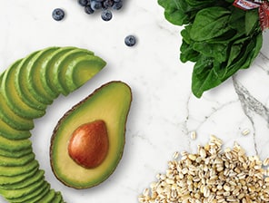 Avocado cut into slices with spinach bunch, oats, and blueberries