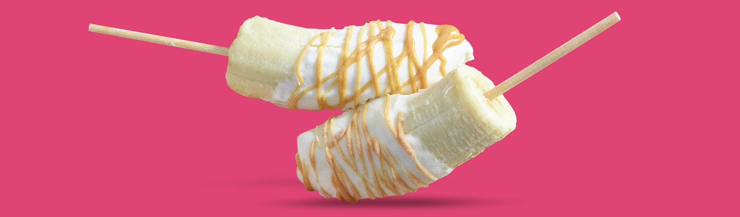 Bananas dipped with yogurt and drizzled with peanut butter