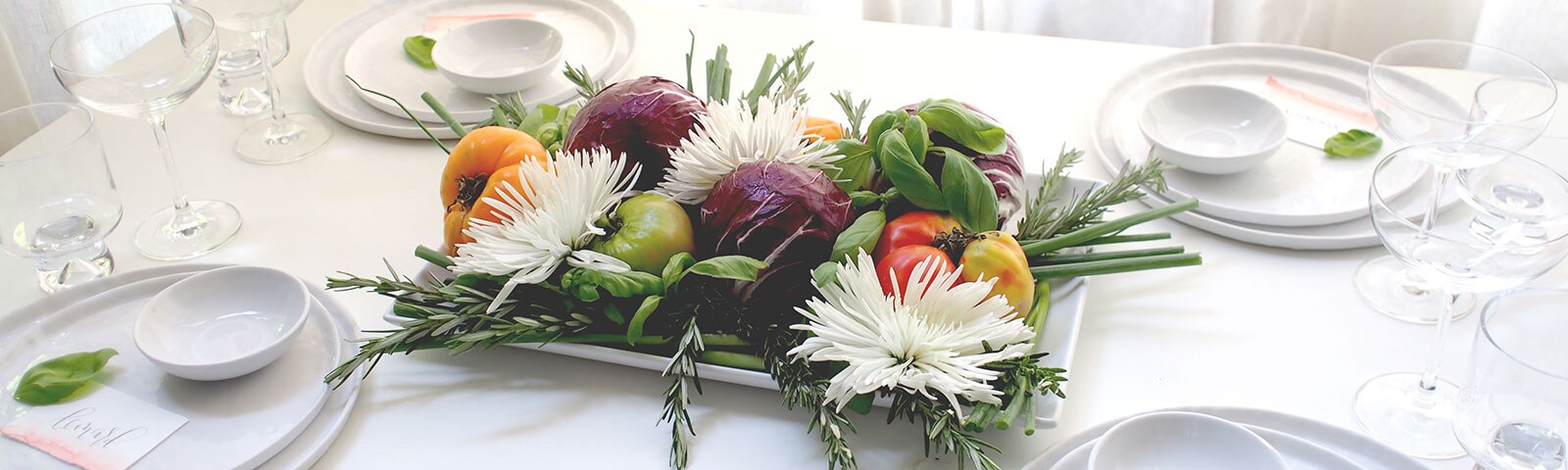 Fruits and veggies on a white platter on a white table