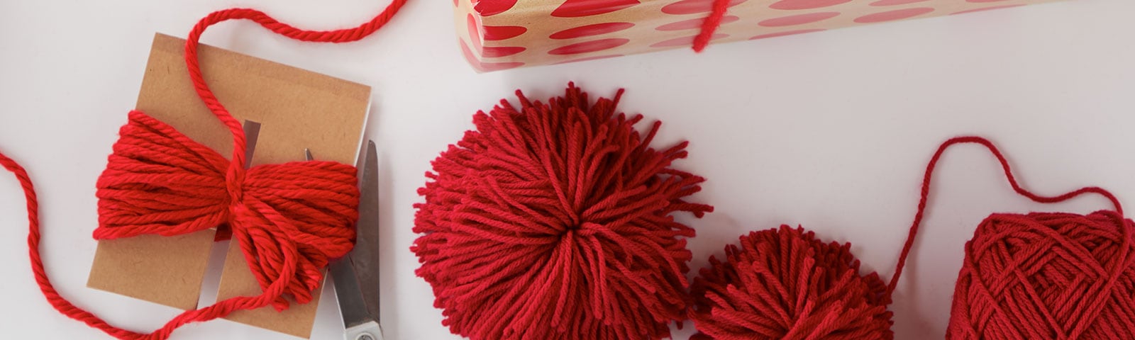Red yarn as gift toppers on gifts