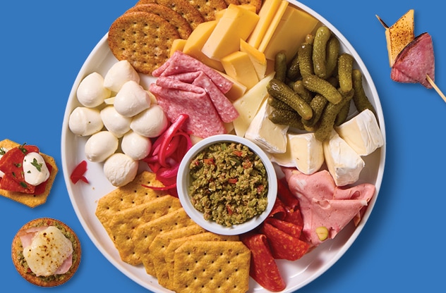 Charcuterie board with assorted crackers, deli meats, fresh cheeses.