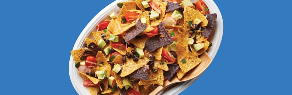 Microwave nachos with tomatoes, black beans, cheese and diced avocados