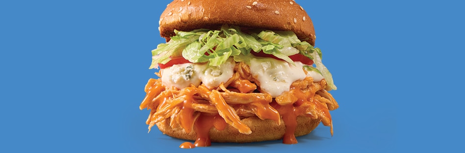Buffalo pulled chicken sandwich with lettuce, ranch and sliced tomatos.
